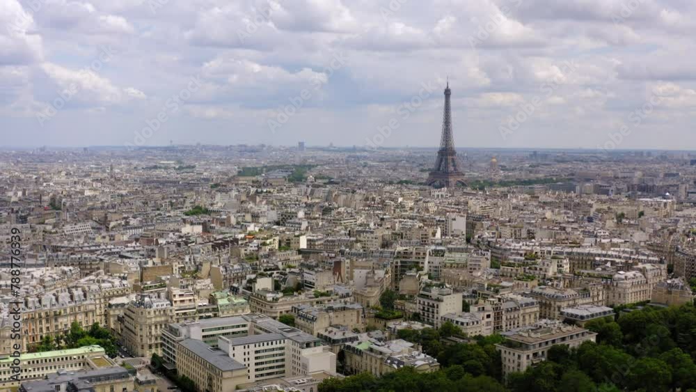 Aerial Backward Shot Of Eiffel Tower With Buildings In City Against Cloudy Sky - Paris, France Aerial Backward Shot Of Eiffel Tower With Buildings In City Against Cloudy Sky - Paris, France
