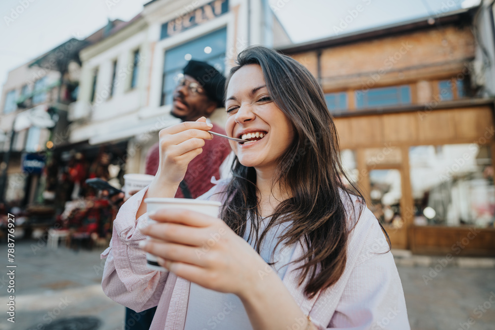 Happy young woman enjoying ice cream with a smiling man behind her in a casual urban setting. Happy young woman enjoying ice cream with a smiling man behind her in a casual urban setting.