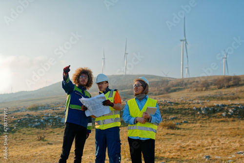 A team of engineers and workers oversees a wind turbine project at a modern wind farm, working together to ensure the efficient generation of renewable energy