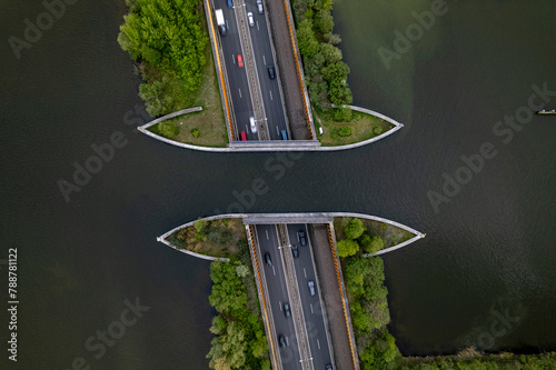 Highway with traffic passing underneath Veluwemeer aquaduct seen from above. Top down aerial showing Dutch waterway infrastructure for boats to pass over  freeway.  photo