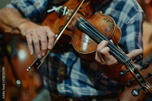 A man passionately plays the violin in a warmly lit room, his fingers dancing across the strings as music fills the space.