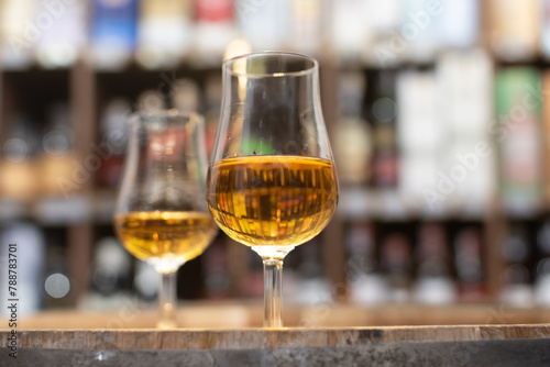Whisky glass close-up on colorful blurred background on oak barrel