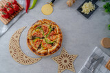 Pizza with fresh vegetables on gray background