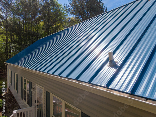 New steel metal light blue roof on a single family home featuring 5V style panels.  photo