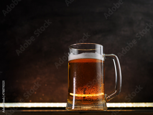 Light beer mug on a dark background. Back light, copy space