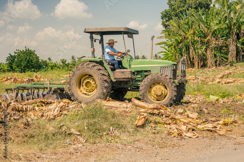 Farmer prepares the land for planting and uses a tractor.