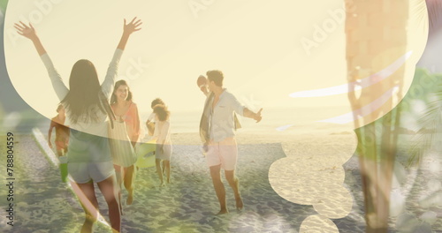 Group of friends enjoying time on beach, arms raised, laughing