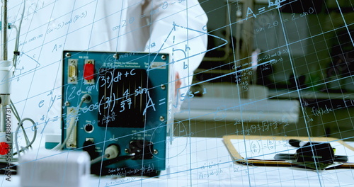 Person in lab coat stands behind glass board with equations in school