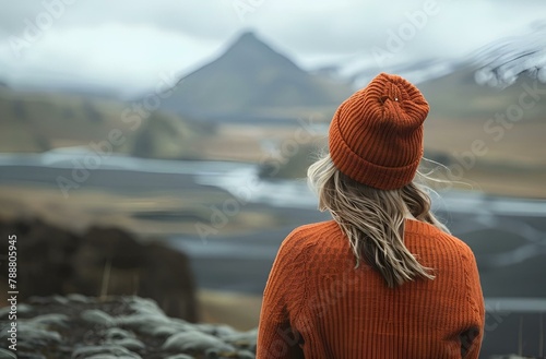 AI generated illustration of a woman in a hat standing on a mountainside