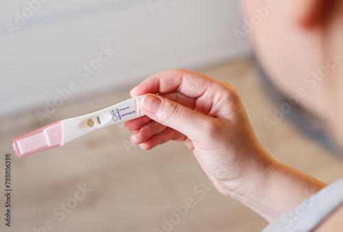 Close up top view of a woman holding a positive pregnancy test