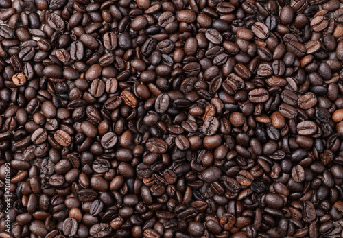 Closeup, top view of coffee beans over rustic wooden table