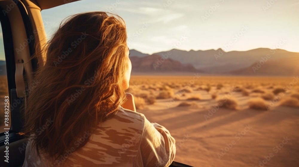 Young woman looking out the window at the vast desert landscape. She is filled with wonder and awe at the beauty of nature. Young woman looking out the window at the vast desert landscape. She is filled with wonder and awe at the beauty of nature.