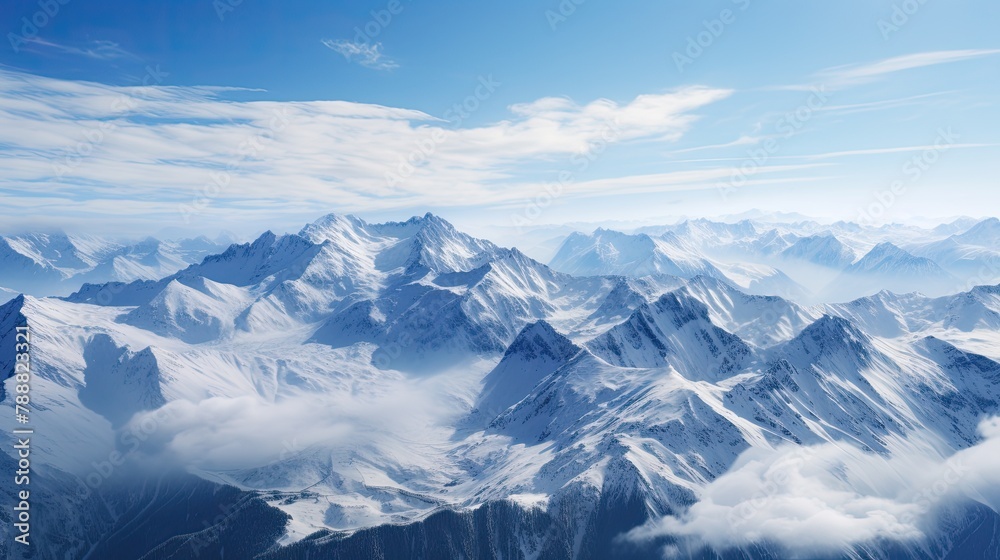 Fototapeta premium This is a beautiful landscape photograph of snow-capped mountains. The image is taken from a high angle and looks down on the mountains.
