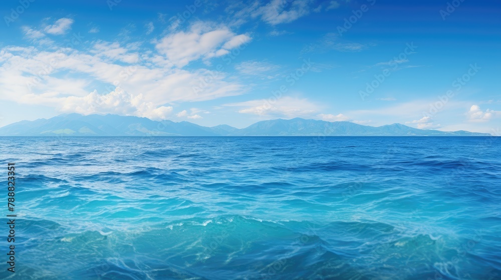 Beautiful seascape with blue sky and white clouds. The deep blue ocean is crystal clear with small waves.