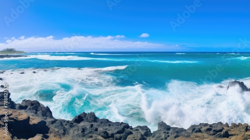 Beautiful seascape with large waves crashing on a rocky coast. The water is a deep blue color and the sky is bright blue with a few white clouds.