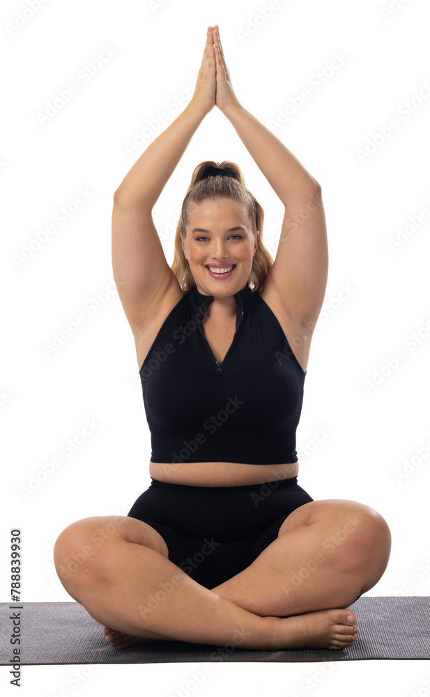 Caucasian young female plus size model on white background practicing yoga, sitting on mat Caucasian young female plus size model on white background practicing yoga, sitting on mat