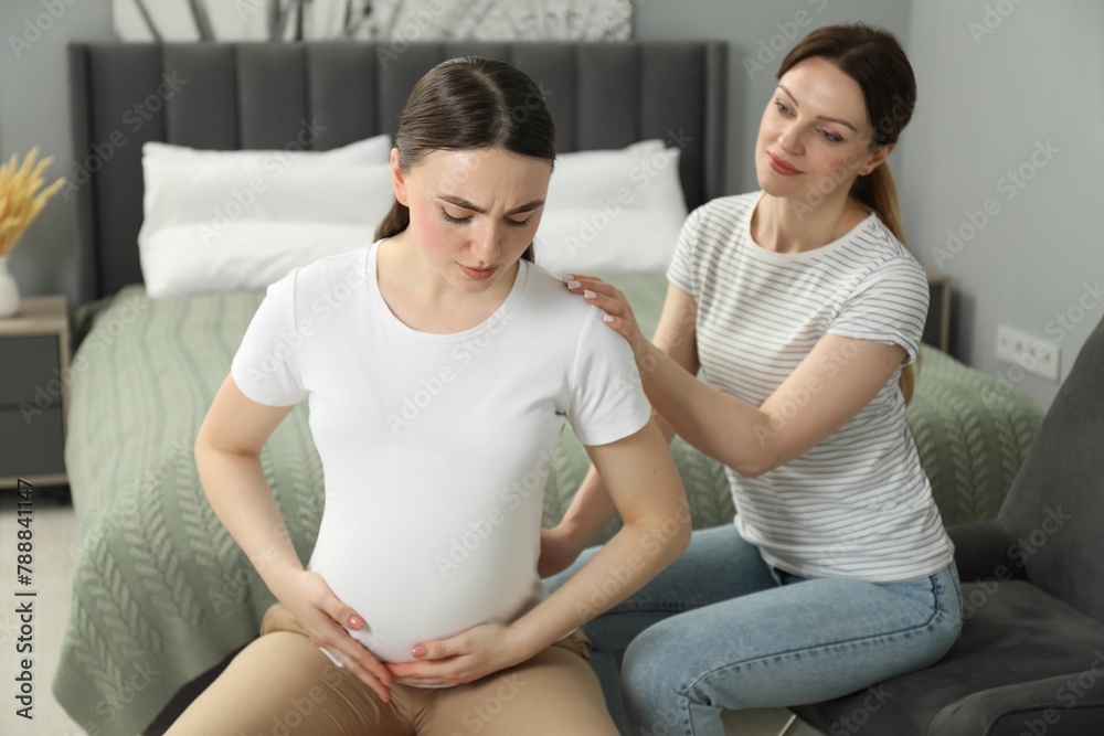Doula taking care of pregnant woman in bedroom. Preparation for child birth Doula taking care of pregnant woman in bedroom. Preparation for child birth