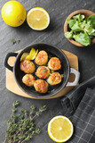 Delicious fried scallops and ingredients on dark gray textured table, flat lay