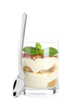Delicious tiramisu in glass, mint leaves and spoon isolated on white