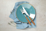 Setting with beautiful cutlery on textured table, top view
