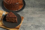 Delicious chocolate truffle cake and fork on grey textured table, space for text