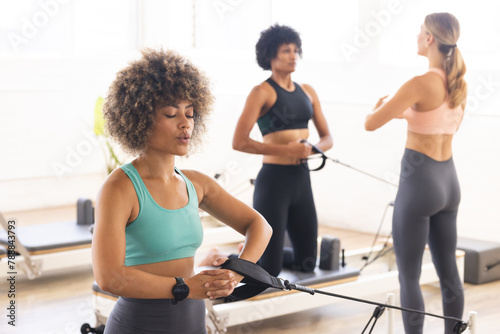 Diverse group of women practicing reformer pilates at studio
