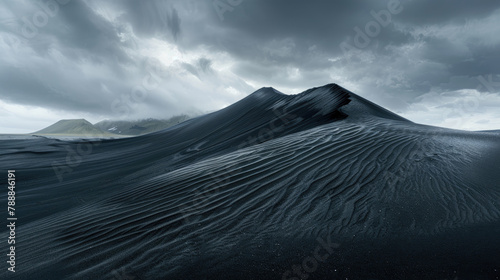 Silken black dunes unfolding beneath the gaze of mountains and moody skies
