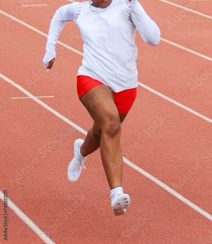 One girl running a race in lane on an outdoor track