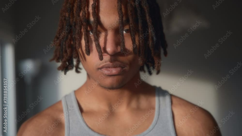 A young man with dreadlocks looking at the camera under the evening light. Slow motion. A young man with dreadlocks looking at the camera under the evening light. Slow motion.