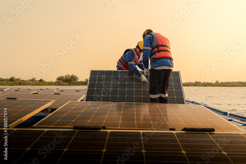 Male workers repair Floating solar panels on water lake. Engineers construct on site Floating solar panels at sun light. clean energy for future living. Industrial Renewable energy of green power. photo