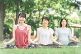 新緑の公園でヨガ教室をする女性達（ムドラー・パークヨガ・瞑想・ピラティス）
