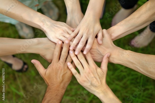 A group of people are holding hands in a circle. The people are of different races and genders. Concept of unity and togetherness