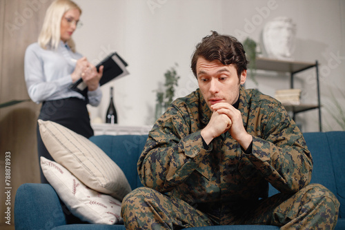 Soldier in military uniform talking to psychiatrist at therapy session