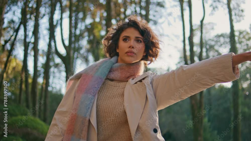 Traveler stopping passing car on sunlit forest road wearing stylish coat closeup Traveler stopping passing car on sunlit forest road wearing stylish coat closeup