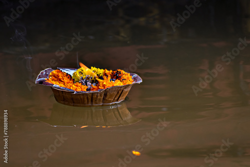 Isolated image of a floating lamp with flowers and candle offered to holy river Ganges at Varanasi Ghats.