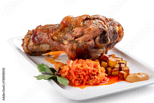 Pork knuckle baked in the oven in a plate with stewed cabbage and potatoes on a white background. Bavarian meat dish