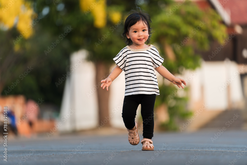 happy toddler girl running in park