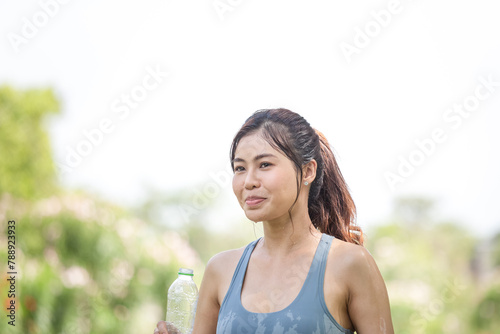 Asian sportswoman cools down by pouring fresh water, female fitness pouring water over her perfect body