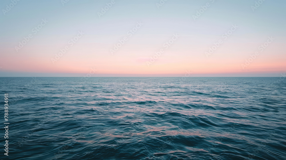 Fototapeta premium Minimalist sunrise over a calm ocean with a subtle gradient sky and a hint of light on the water