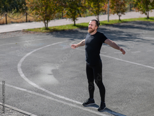 Bearded man doing exercises outdoors.  © Михаил Решетников