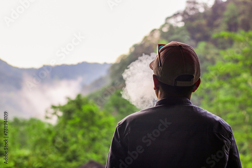 person with cigarette smoke in the mountains © Musrifin
