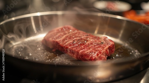 Large, beautiful striped Wagyu steak being cooked on a stainless steel pan.