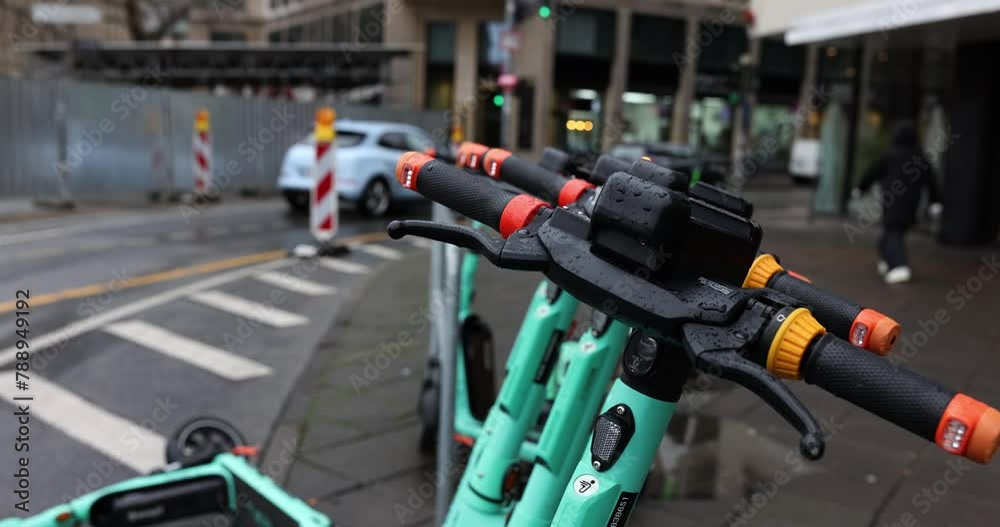 Scooters for rental stand near building in urban area Scooters for rental stand near building in urban area