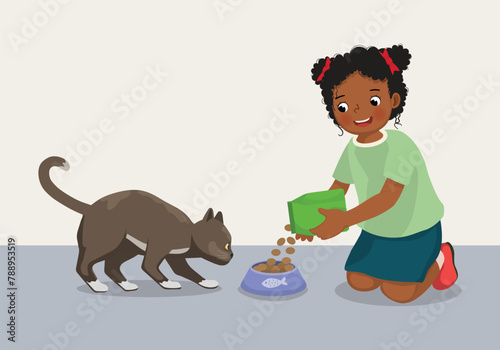 Cute little African girl feeding her pet cat with animal food at home
