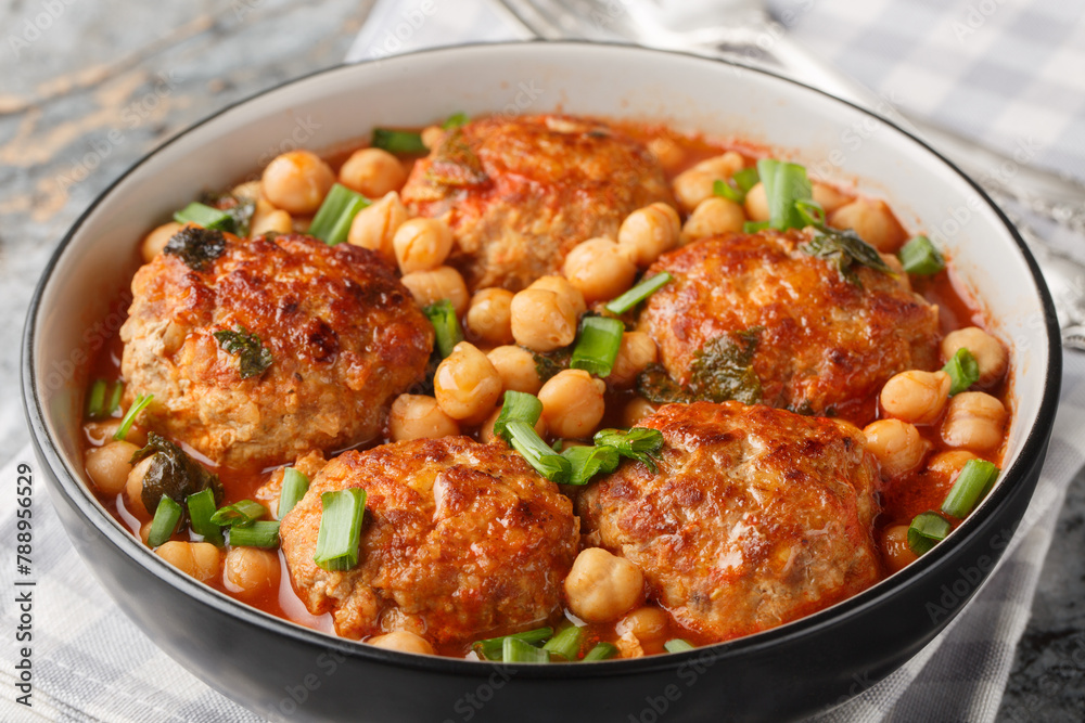 Spicy fried meatballs with chickpeas, tomato, mint and green onions close-up in a bowl on the table. Horizontal