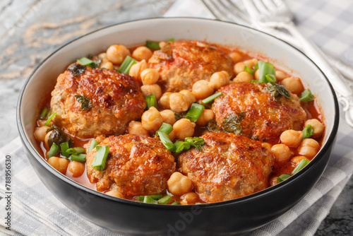 Homemade meatballs served with chickpeas, tomato and green onions close-up in a bowl on the table. Horizontal