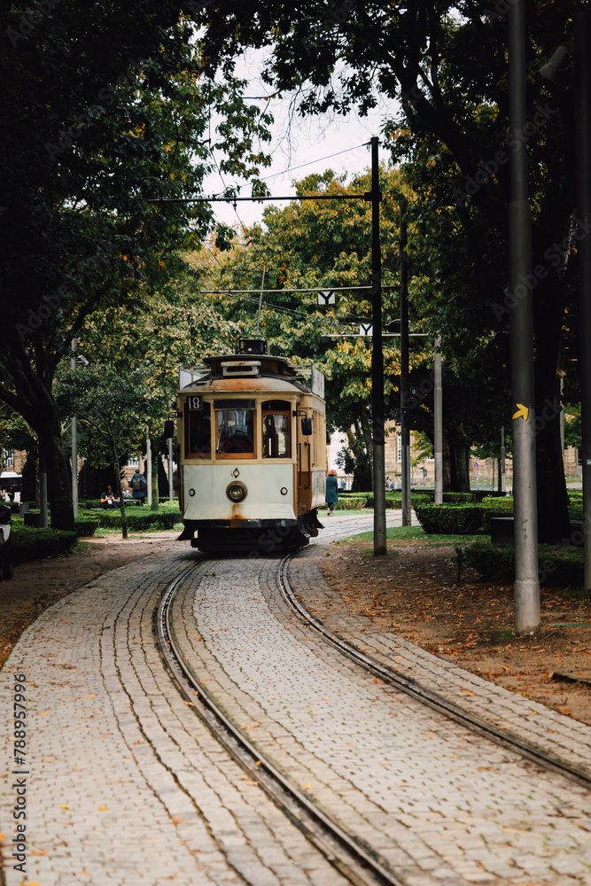 Naklejka premium View of a park with the famous retro tourist streetcar in the old town of Porto, Portugal. Traditional Tram