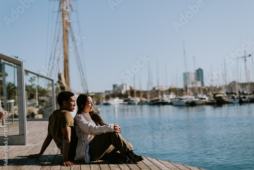 Serene afternoon at Barcelona marina, couple relaxing by tranquil waters