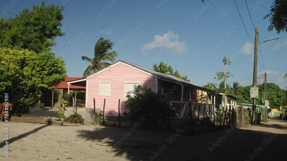 Profile view of a pink hut between trees during afternoon. Profile view of a pink hut between trees during afternoon.