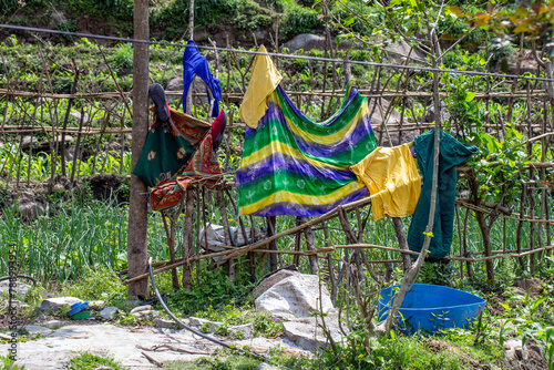 Clothes hung on a fence to dry photo